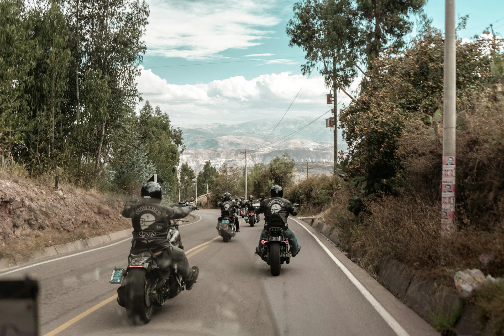 A group of motorcyclists riding together down a country road