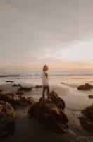 A copied photo of a person on rocks by the sea