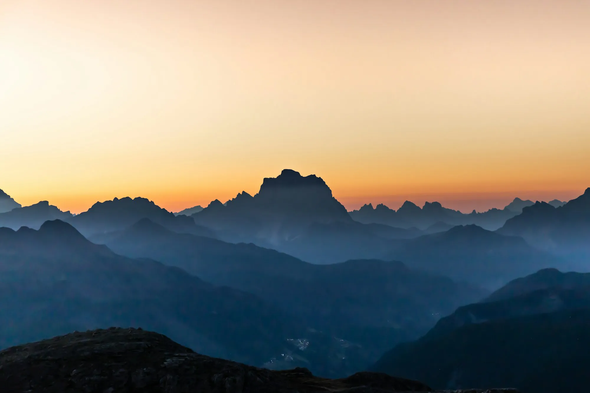 Mountain silhouettes against an orange dusk sky as the Mac desktop wallpaper, with Snippet's notch panel open at the top